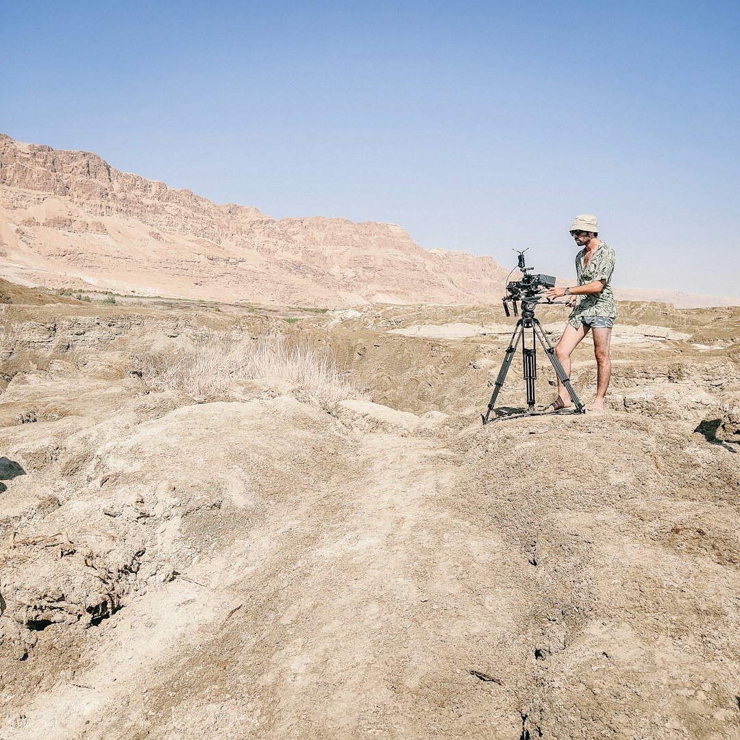 Camera operator filming with a professional video camera on a tripod